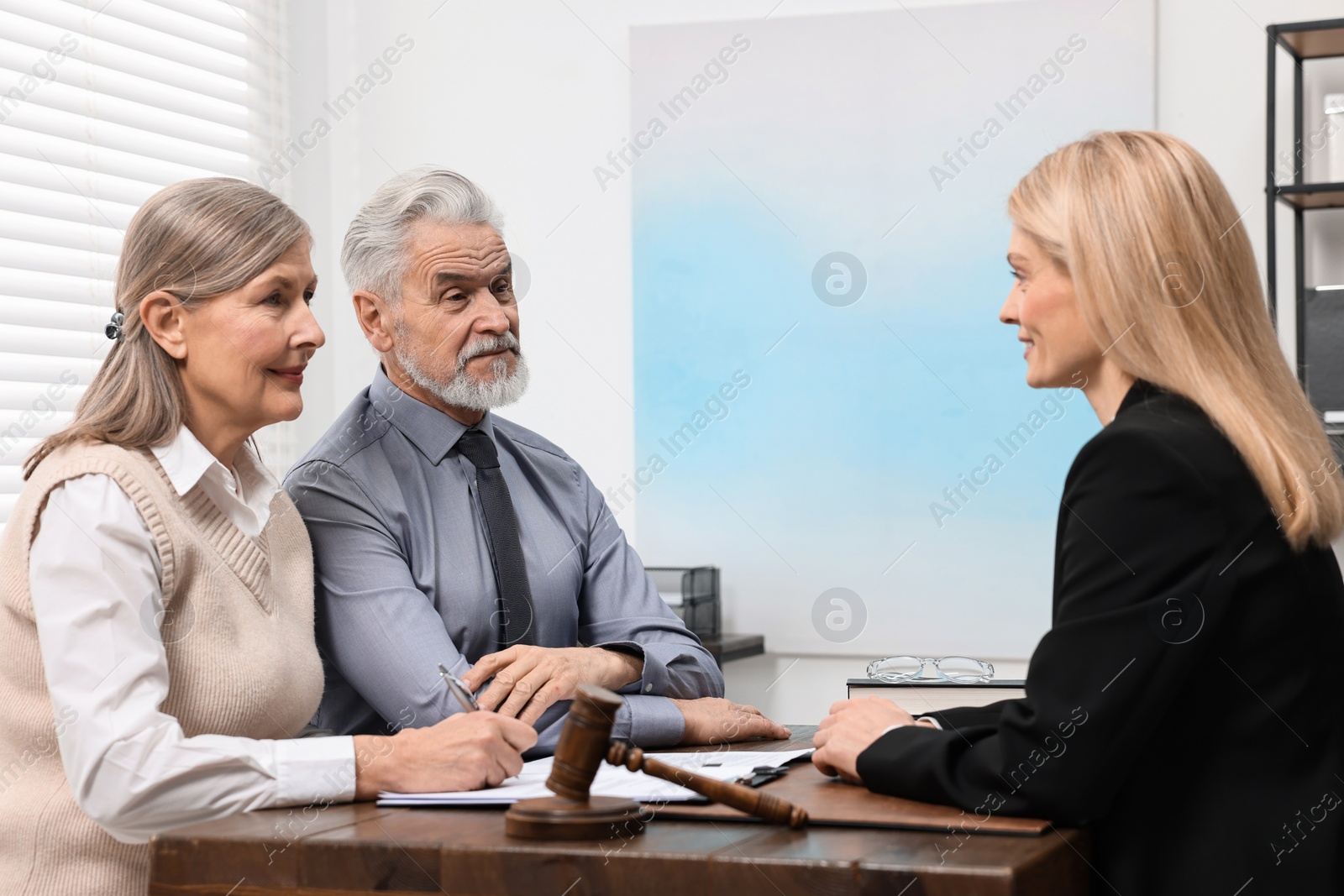 Photo of Senior couple having meeting with lawyer in office