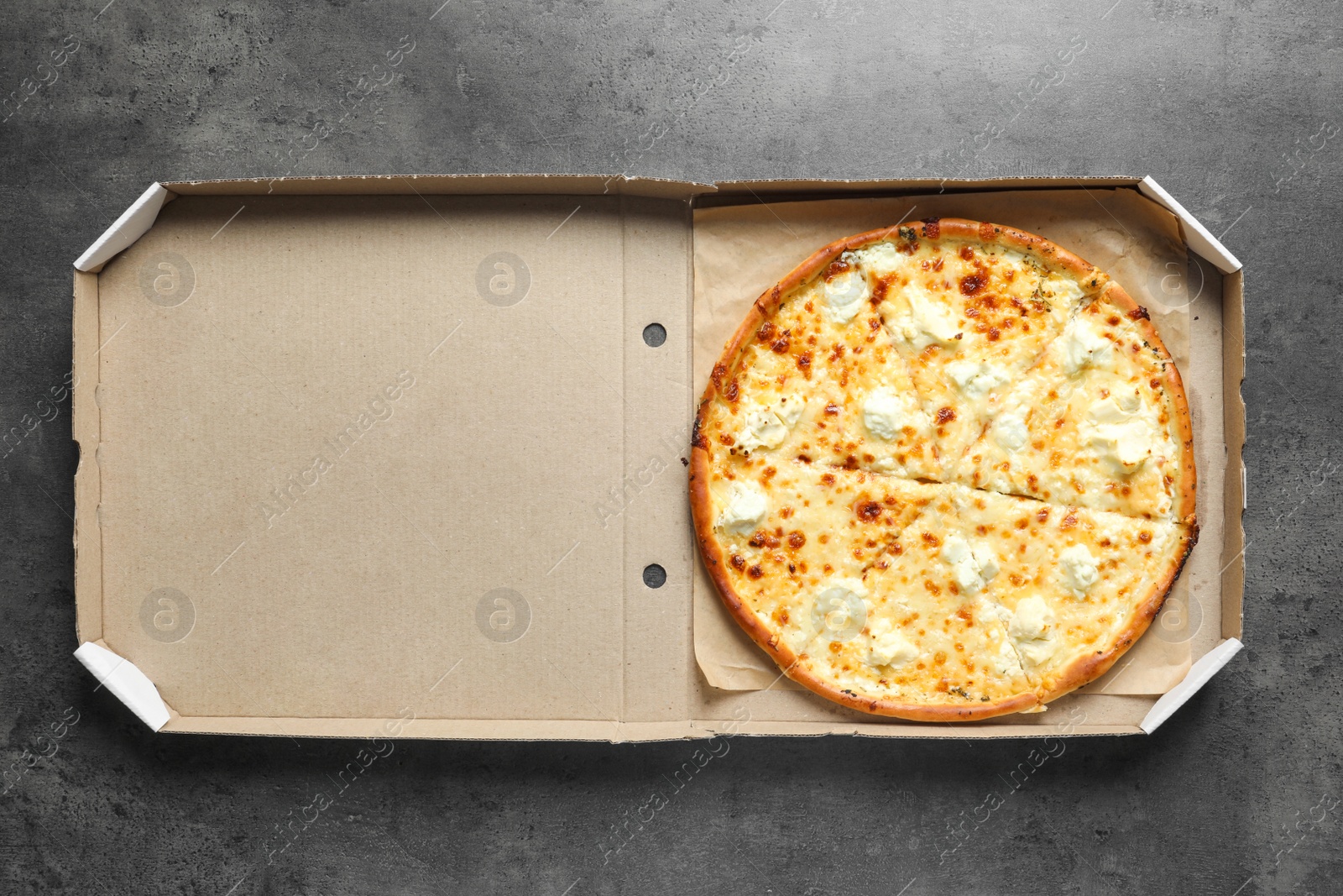 Photo of Carton box with delicious pizza on grey background