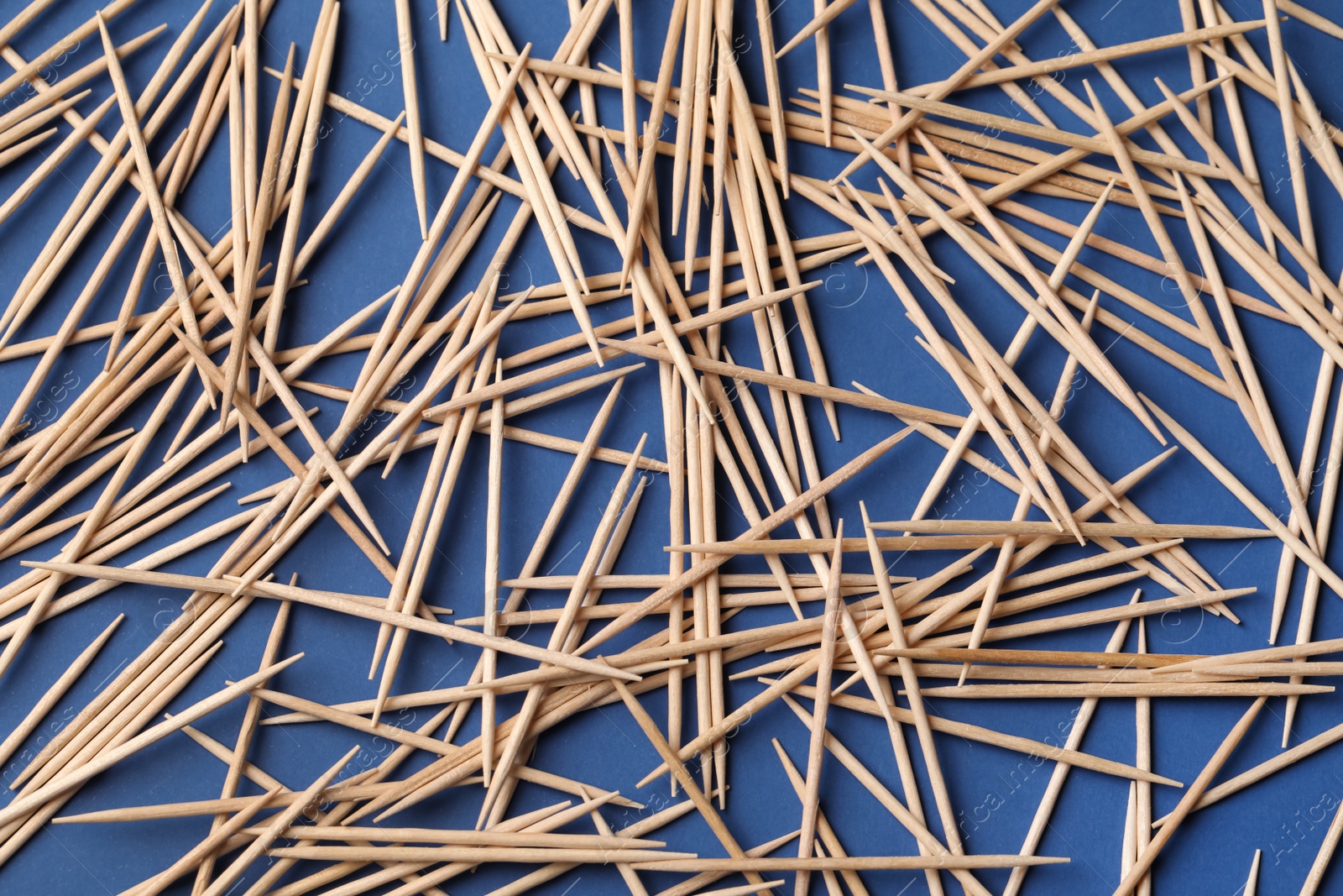Photo of Wooden toothpicks on blue background, flat lay