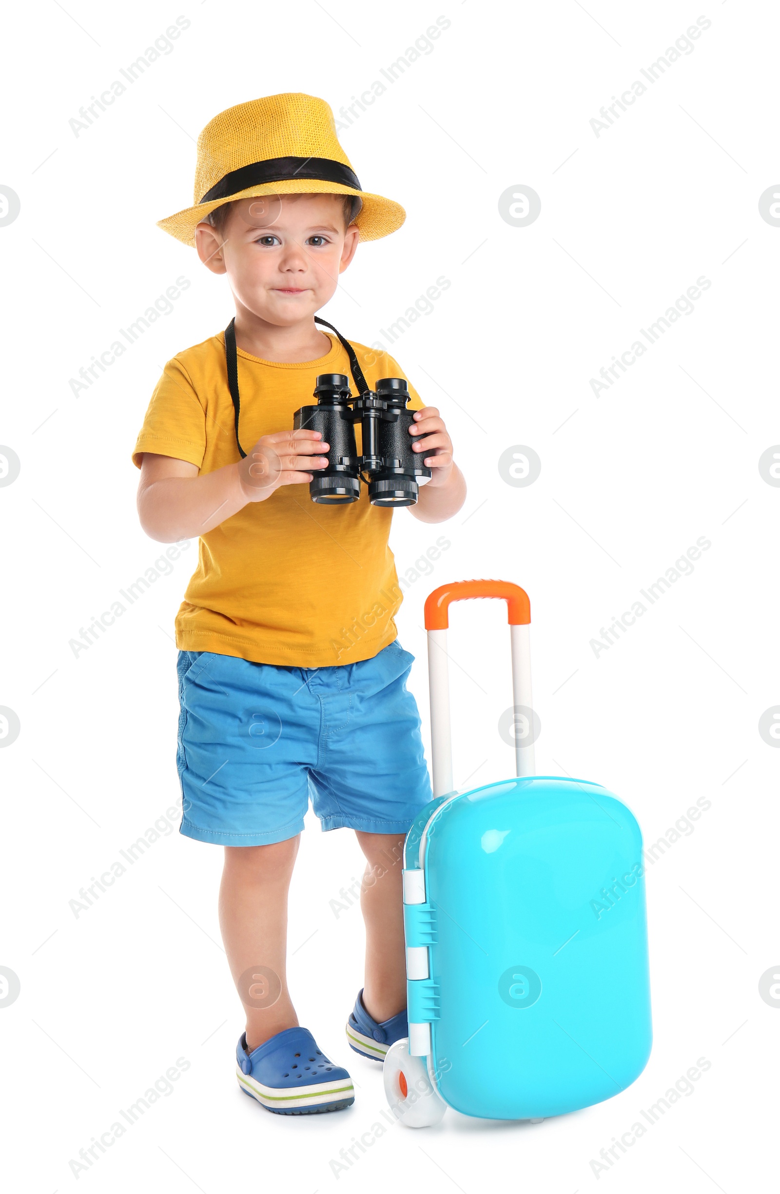 Photo of Cute little boy with hat, binocular and blue suitcase on white background