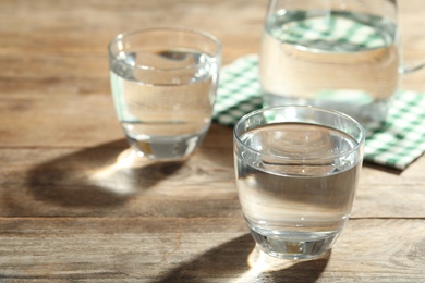 Photo of Glasses of water on wooden table. Refreshing drink