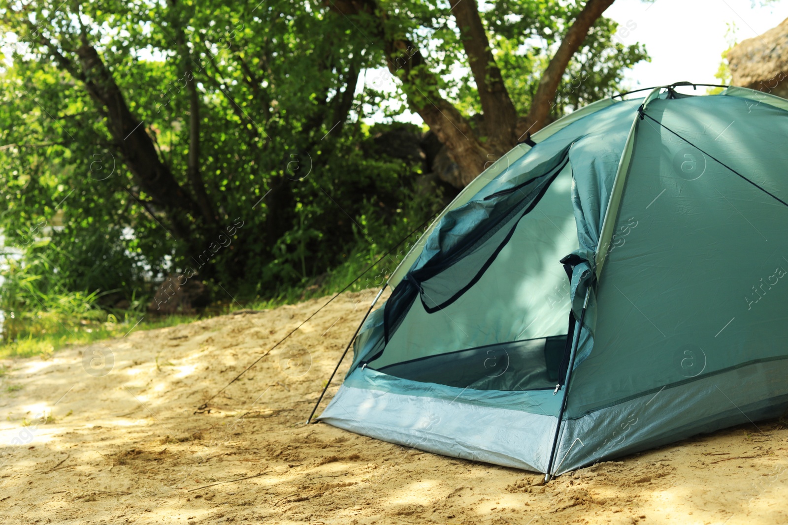 Photo of Modern camping tent in forest. Space for text