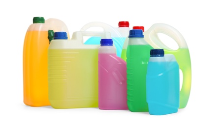 Plastic canisters with different liquids for car on white background