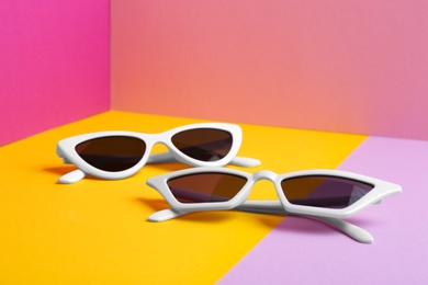 Photo of Stylish sunglasses on color background. Summer time