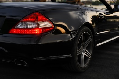 Luxury black convertible car outdoors in evening, closeup