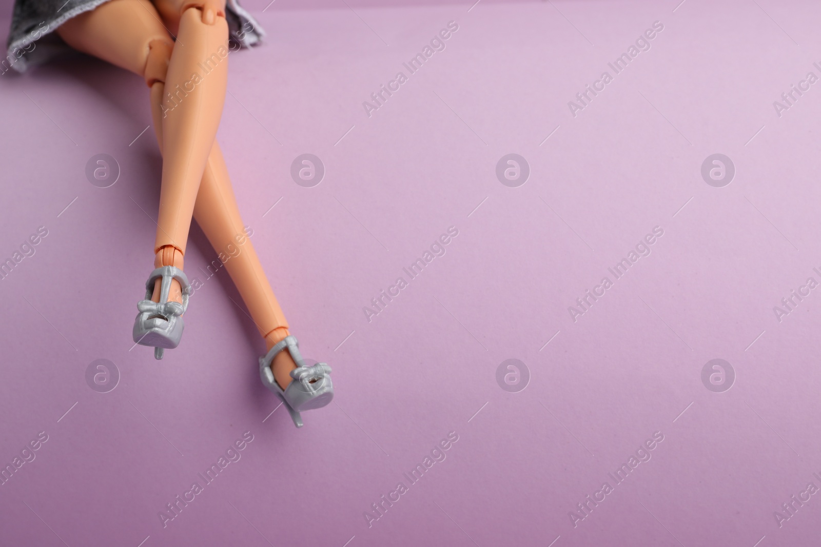 Photo of Mykolaiv, Ukraine - September 4, 2023: Barbie doll wearing beautiful heels on lilac background, closeup. Space for text