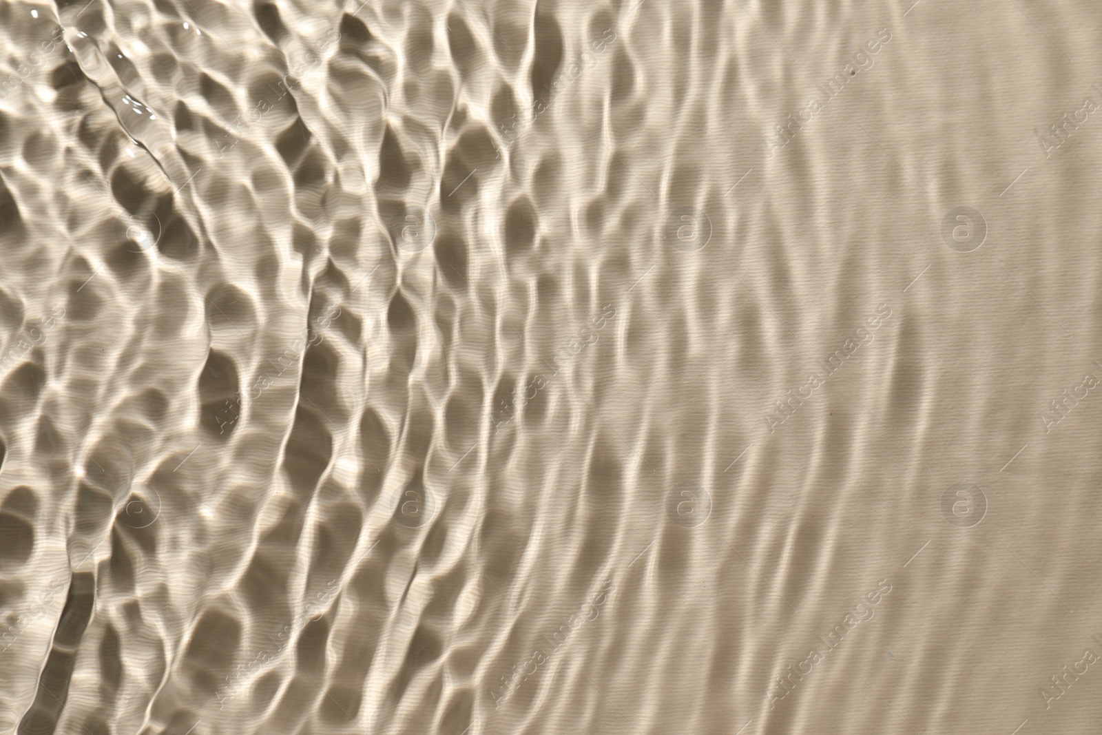 Photo of Rippled surface of clear water on beige background, top view