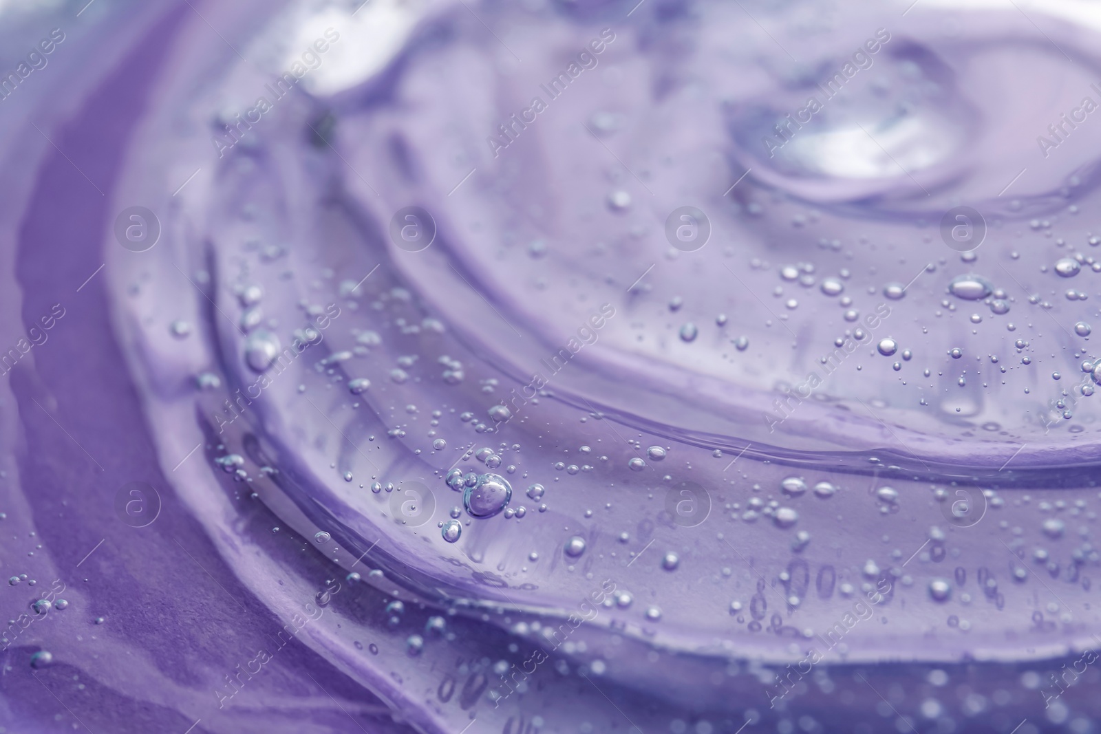 Photo of Transparent shower gel on violet background, closeup