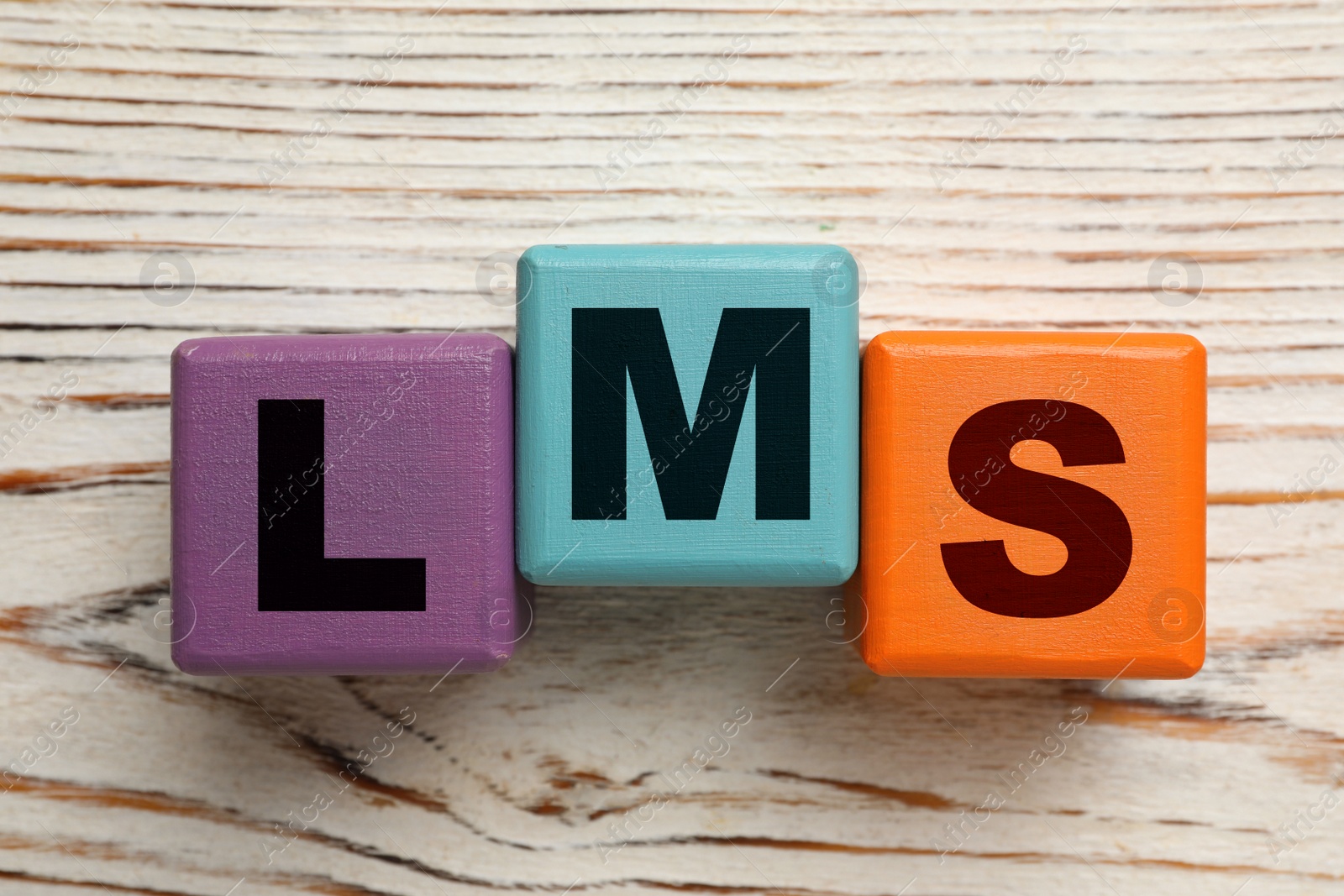 Image of Learning management system. Colorful cubes with abbreviation LMS on wooden background, top view
