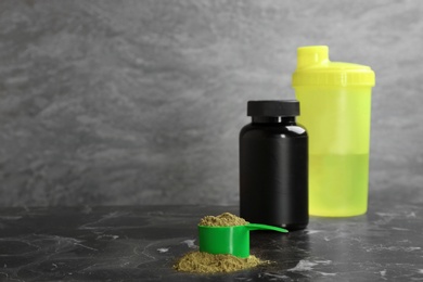 Hemp protein powder in measuring spoon, jar and shaker on table. Space for text