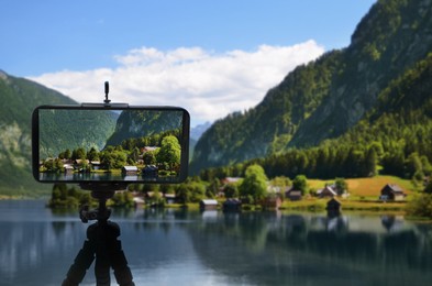 Image of Taking photo of beautiful mountain landscape with smartphone mounted on tripod