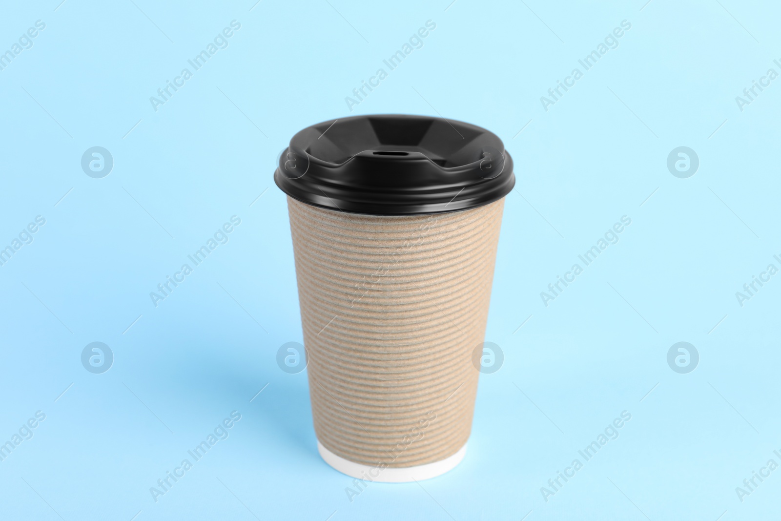 Photo of Paper cup with plastic lid on light blue background. Coffee to go