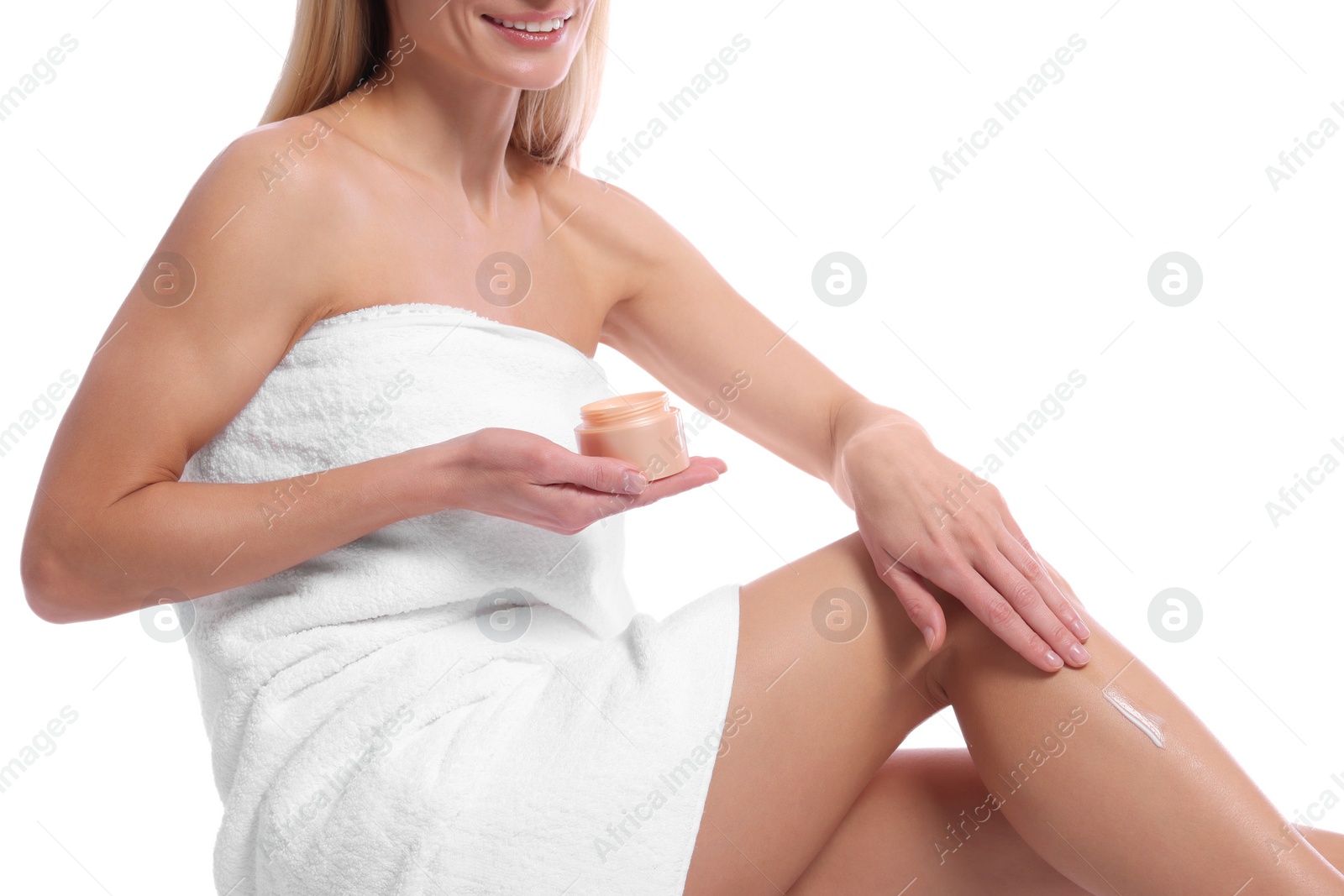 Photo of Woman applying body cream onto her leg against white background, closeup