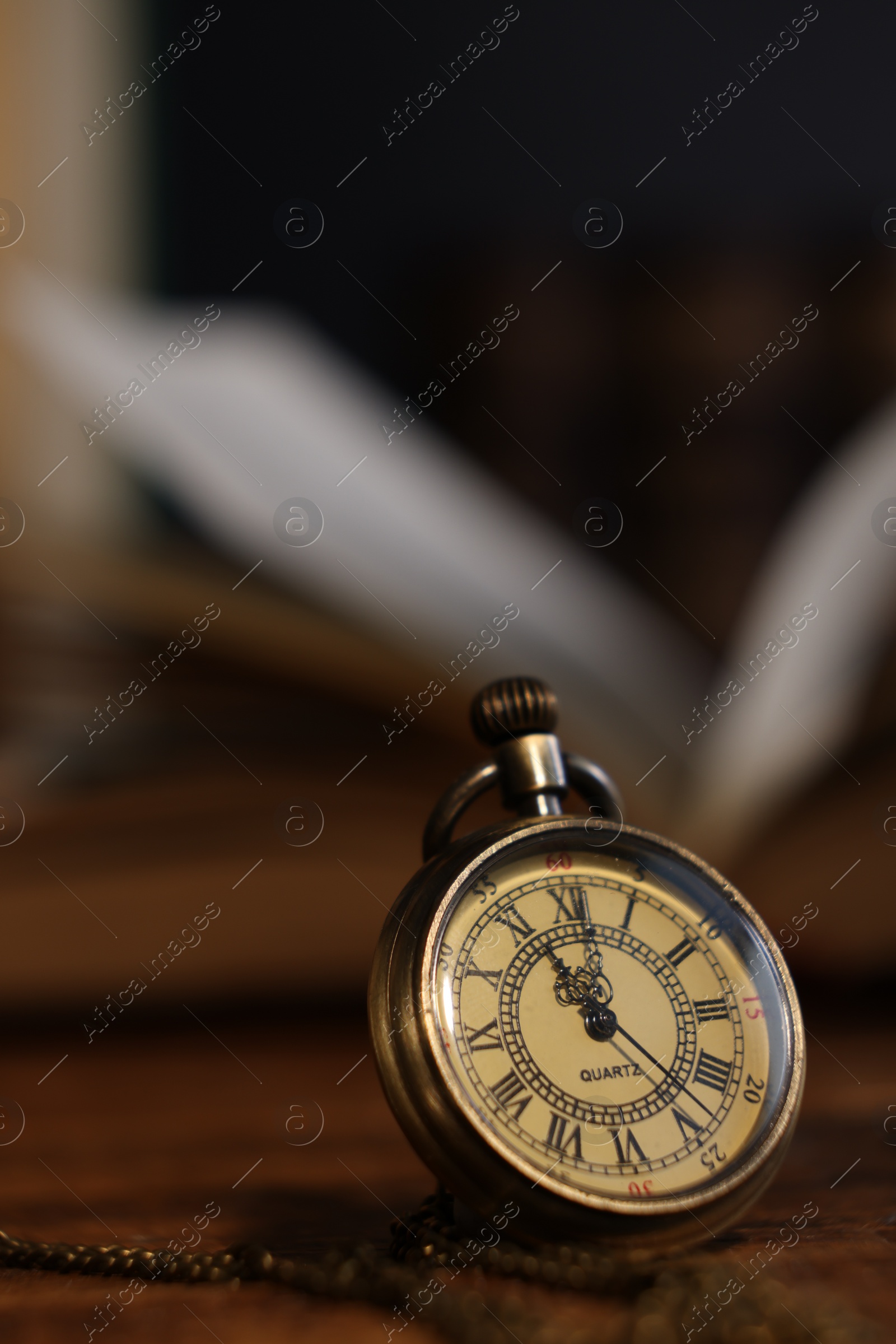 Photo of Pocket clock with chain on table, closeup