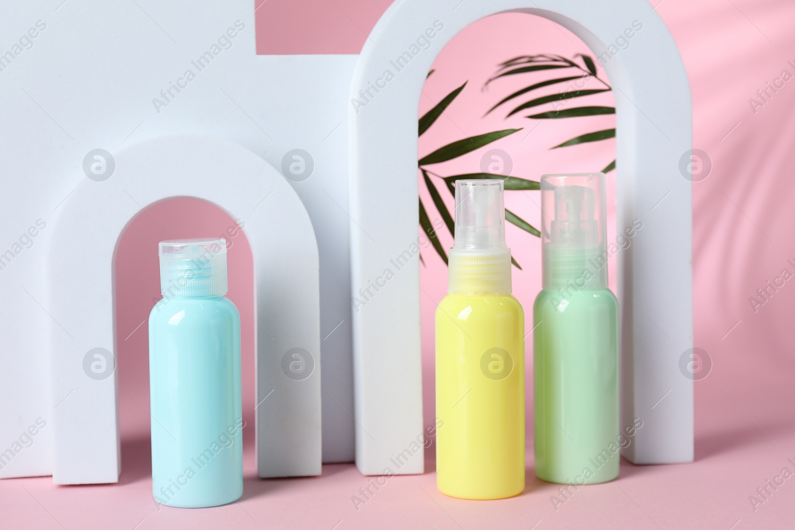 Photo of Cosmetic travel kit and geometric figures on pink background. Bath accessories