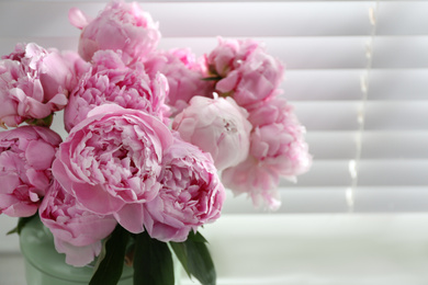 Bouquet of beautiful peonies near window, closeup