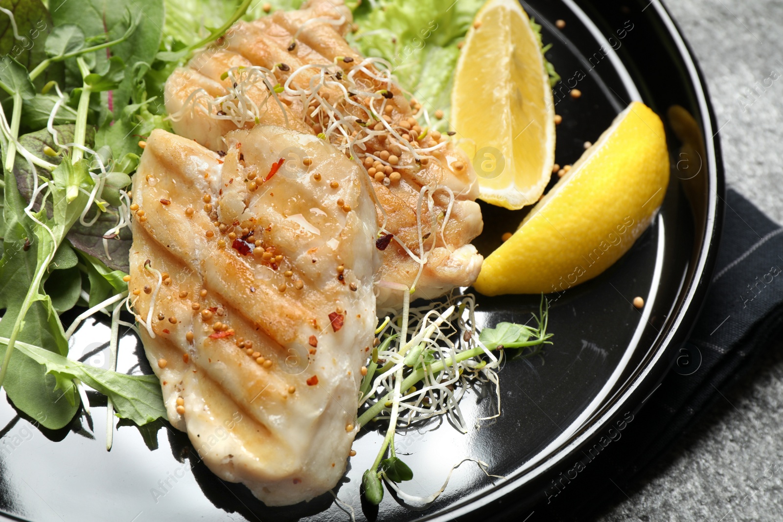 Photo of Plate with tasty grilled fish on table, closeup