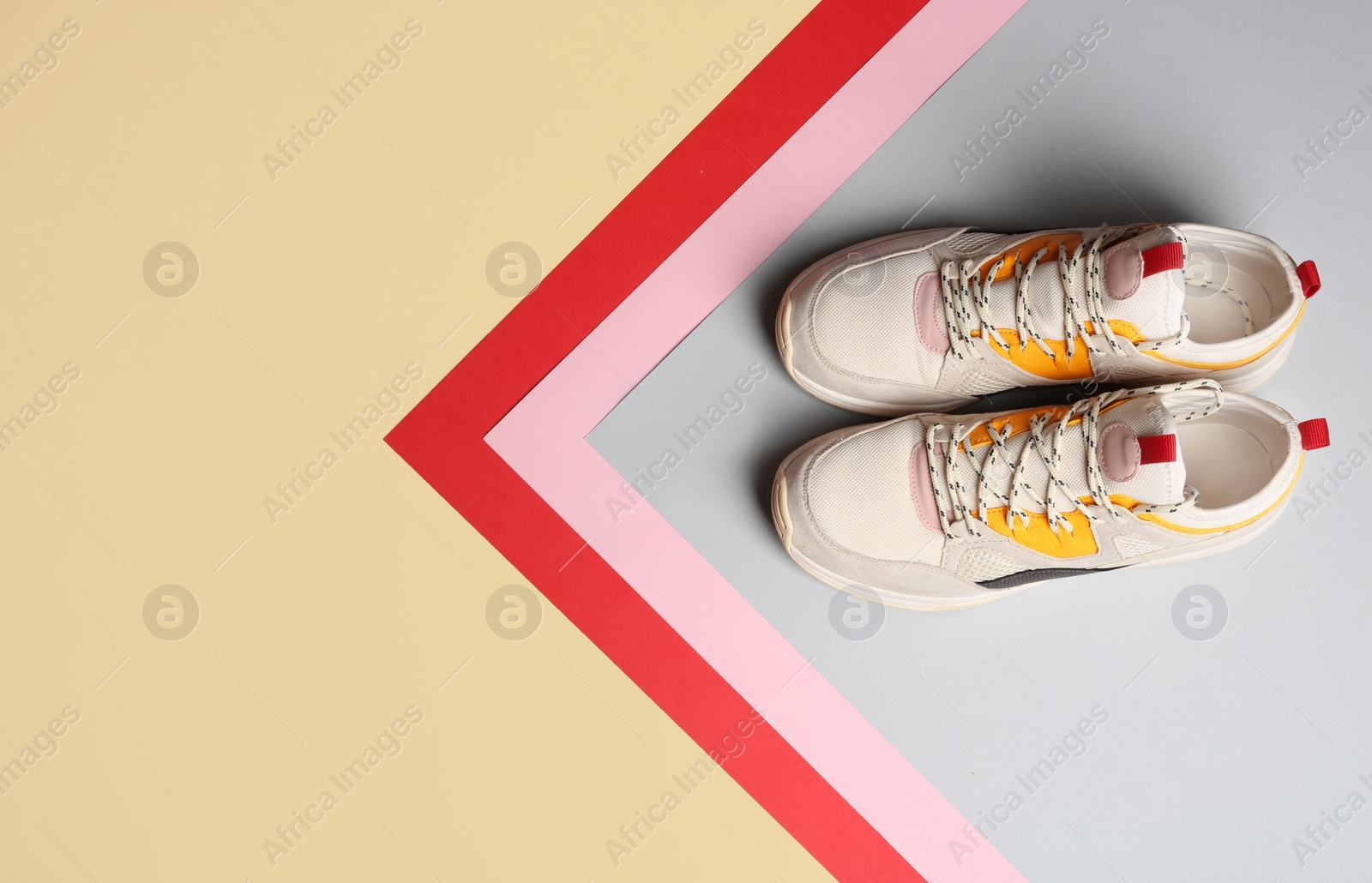 Photo of Pair of sports shoes on color background, top view. Space for text