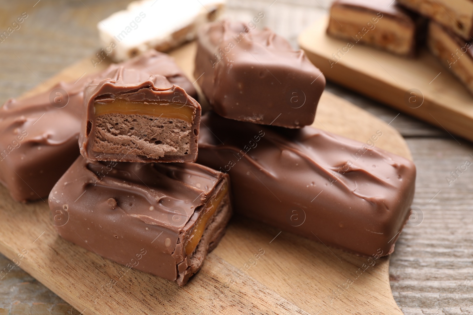 Photo of Tasty chocolate bars with nougat on wooden table, closeup