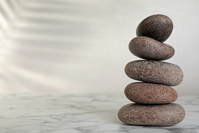 Photo of Stack of spa stones on grey table, space for text