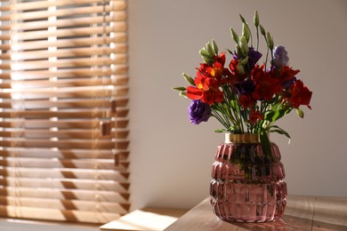 Photo of Vase with beautiful flowers on wooden table in room, space for text