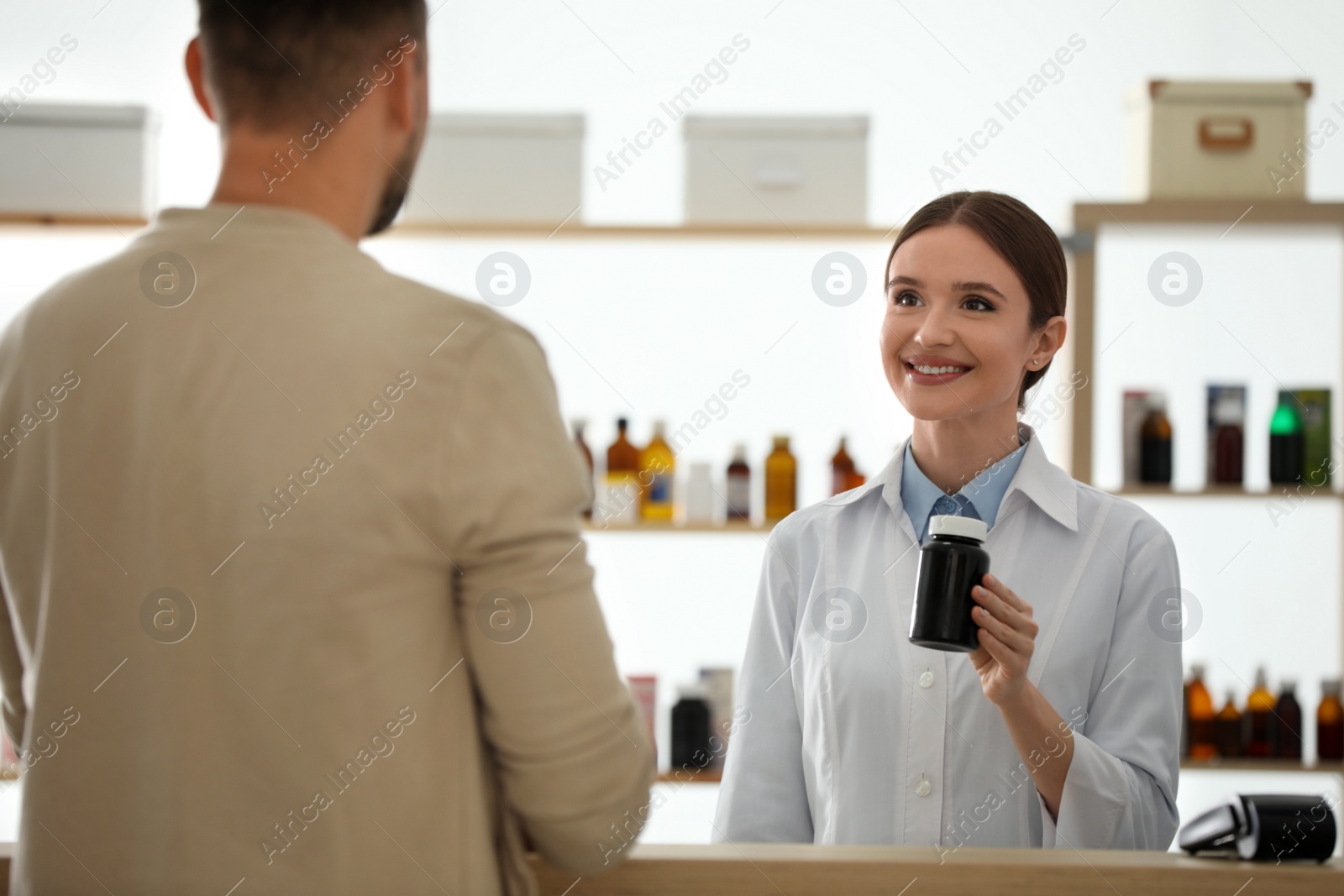 Photo of Pharmacist giving medicine to customer in drugstore