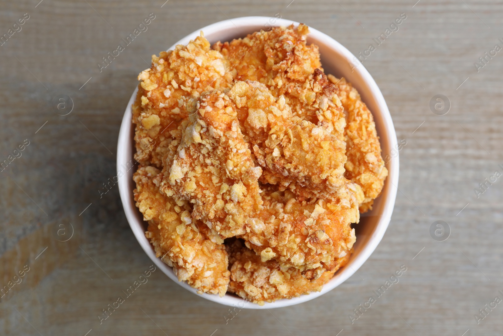 Photo of Bucket with yummy nuggets on wooden table, top view