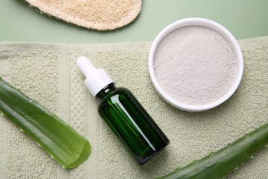 Flat lay composition with cosmetic products and aloe leaves on pale green background