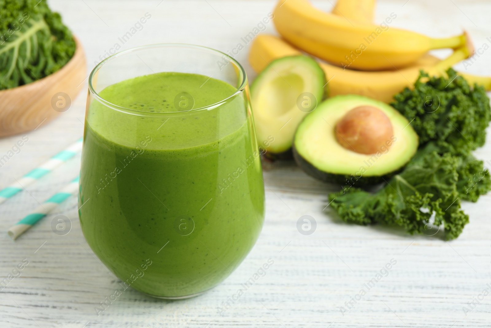 Photo of Tasty fresh kale smoothie on white wooden table, closeup