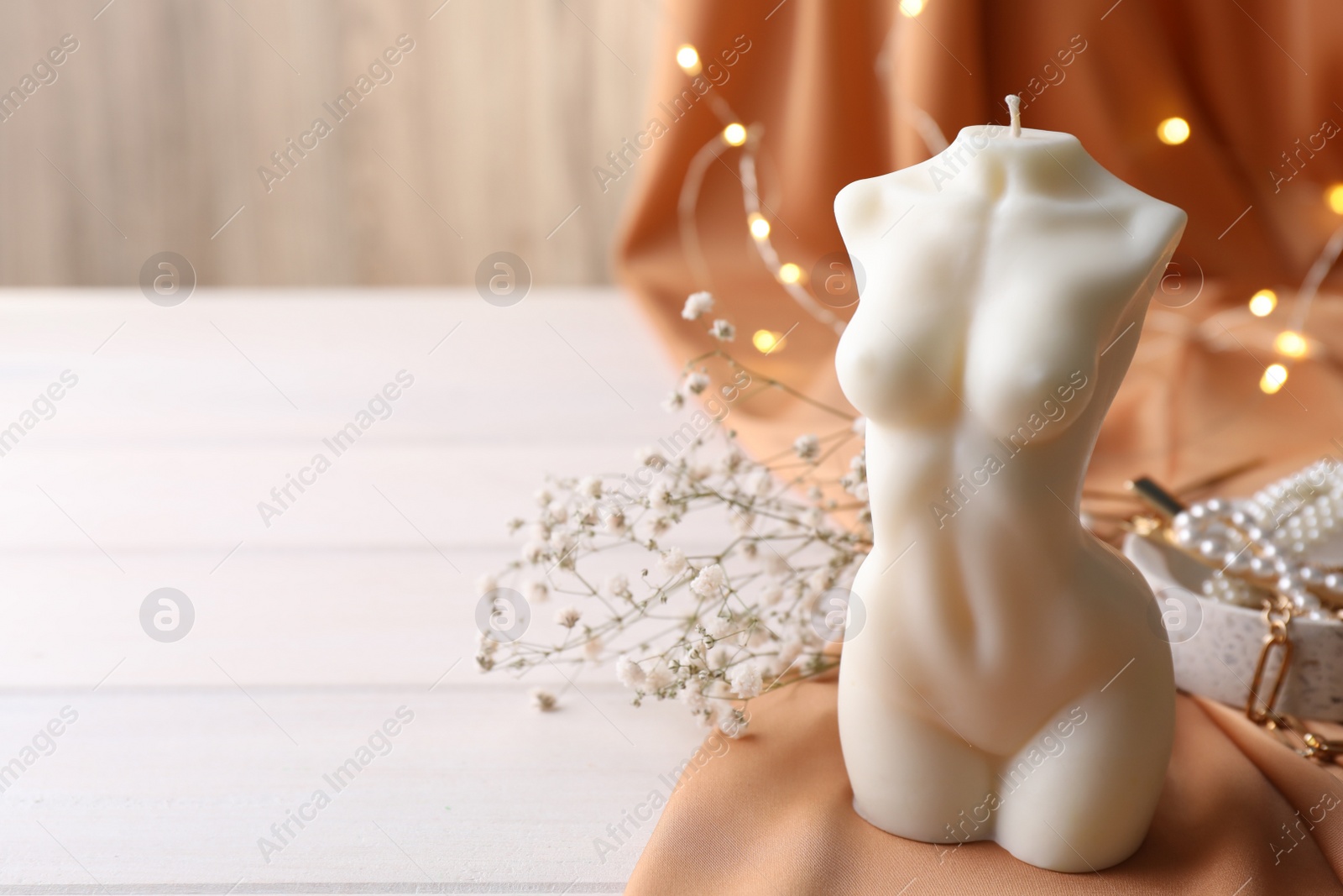 Photo of Composition with beautiful female body shaped candle on white table. Space for text