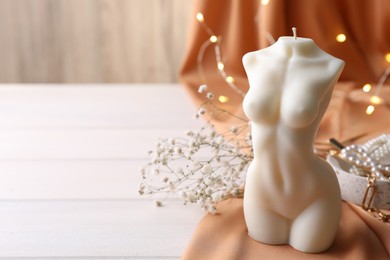 Composition with beautiful female body shaped candle on white table. Space for text