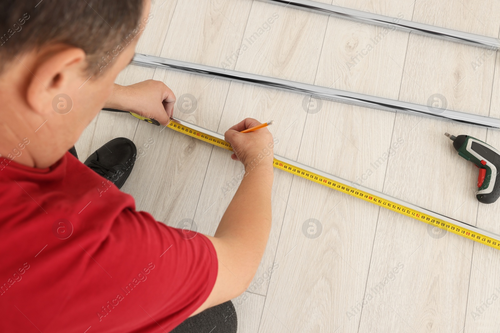 Photo of Worker measuring metal pipes for installation, closeup