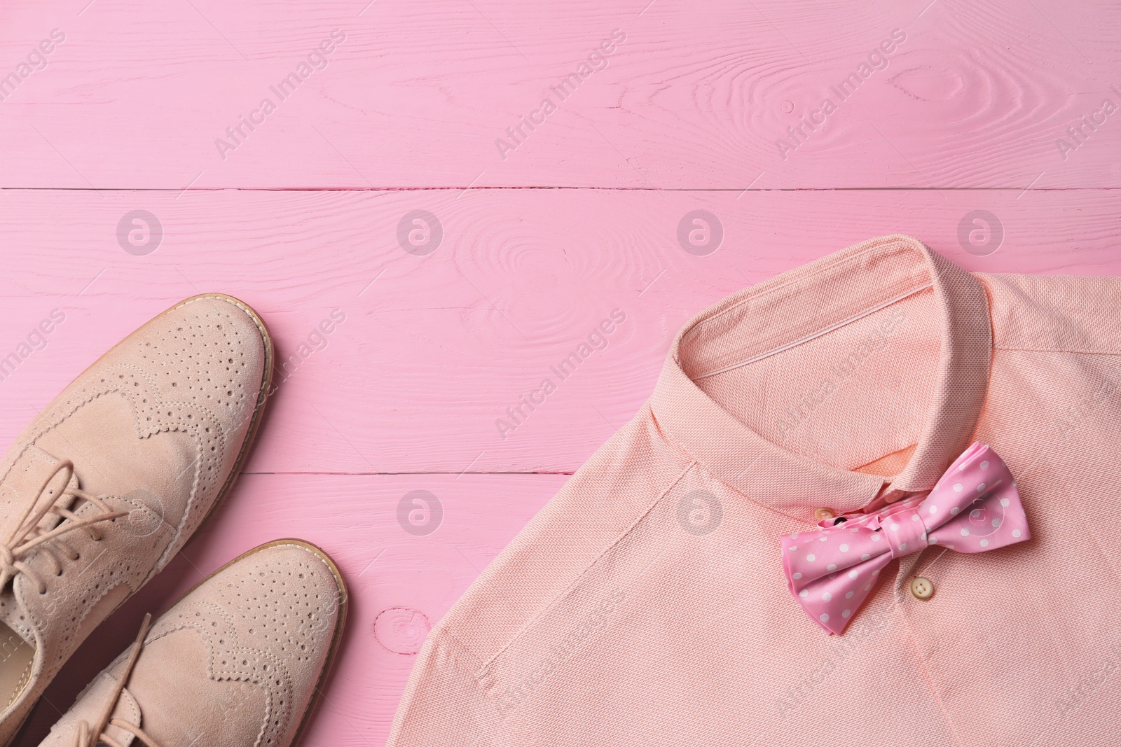 Photo of Flat lay composition with shirt and stylish bow tie on pink wooden background. Space for text