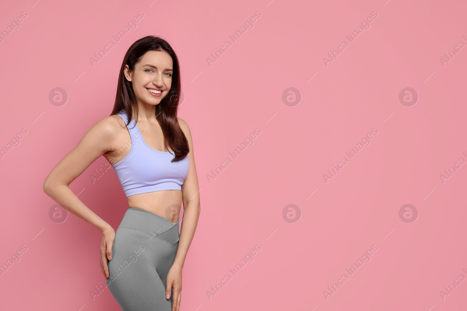 Photo of Happy young woman with slim body on pink background, space for text