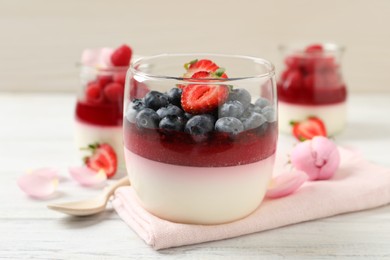Photo of Delicious panna cotta with berries on white wooden table