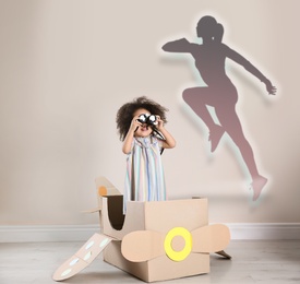 Image of Cute African American girl dreaming to be runner. Silhouette of woman behind kid's back
