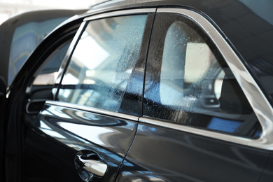 Modern car with wet window before tinting, closeup