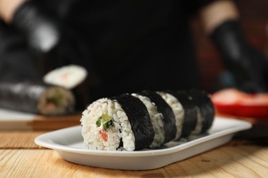 Photo of Tasty sushi rolls on wooden table, closeup