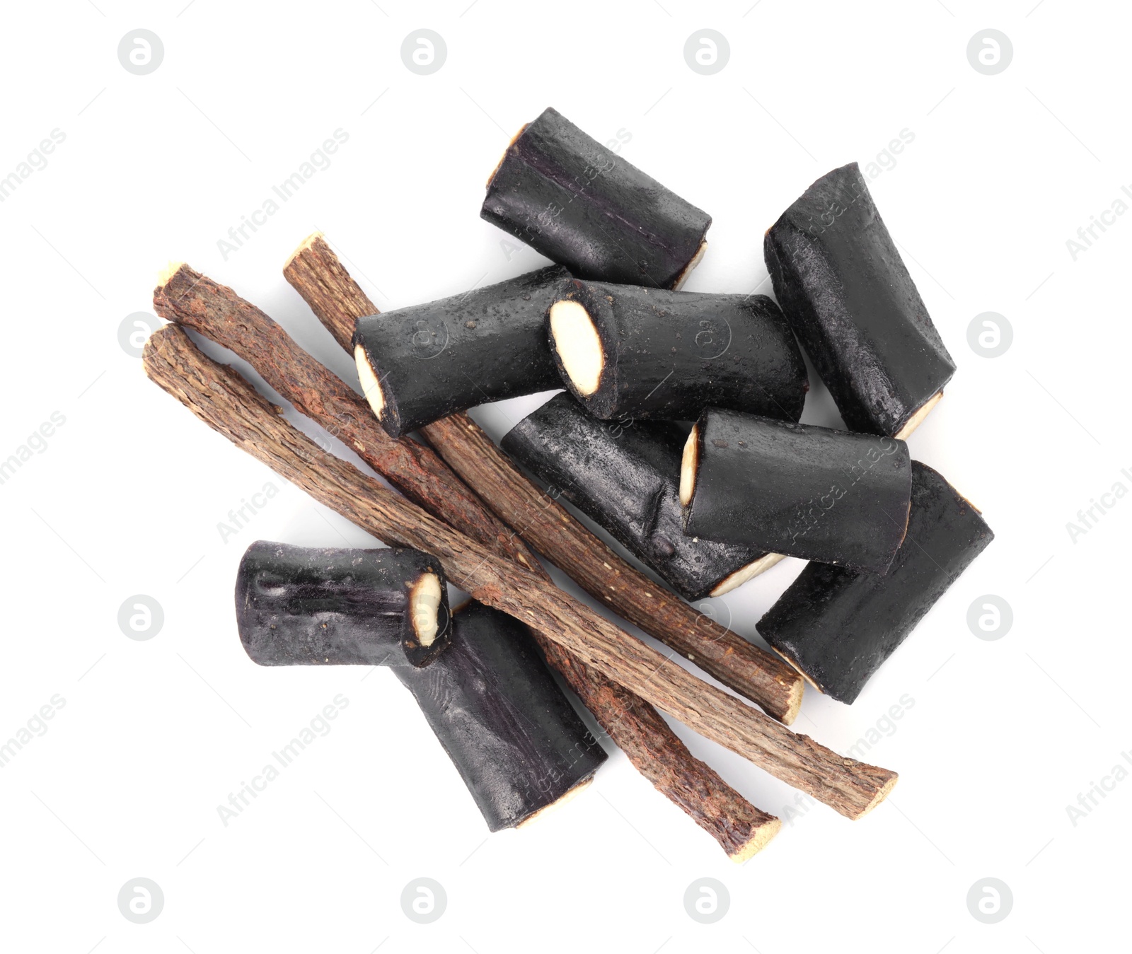 Photo of Many tasty candies and dried sticks of liquorice root isolated on white, top view