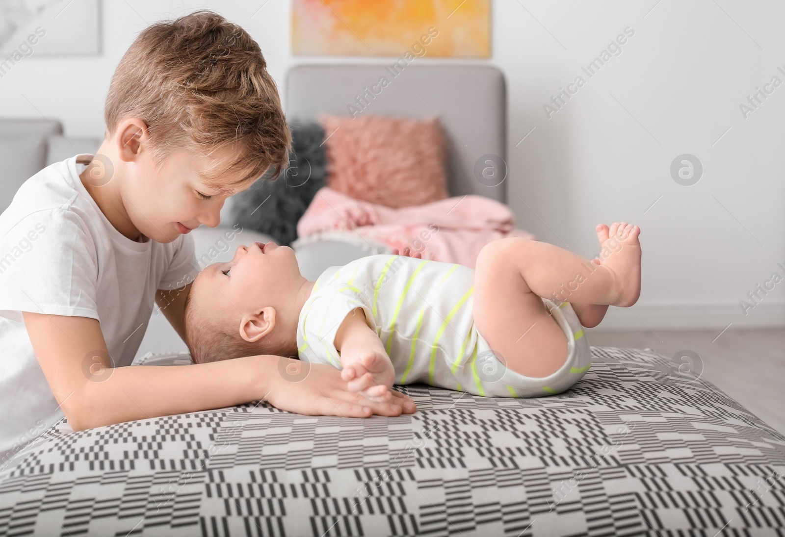 Photo of Cute boy playing with little baby at home