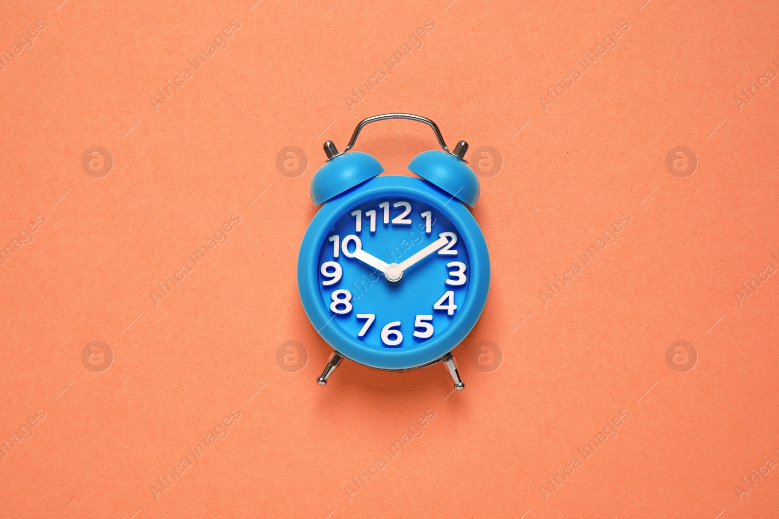 Photo of Alarm clock on orange background, top view. Color of the year 2020 (Classic blue)