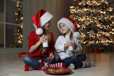 Cute little children with milk and cookies at home. Christmas time
