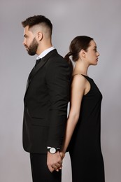 Handsome bearded man with sexy lady on grey background