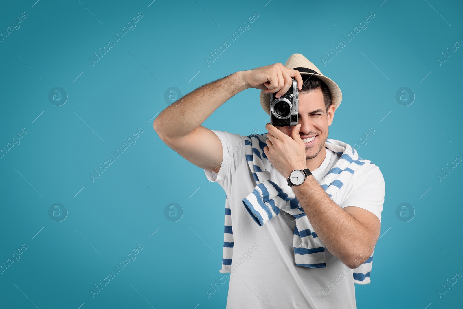 Photo of Male tourist taking picture on turquoise background, space for text