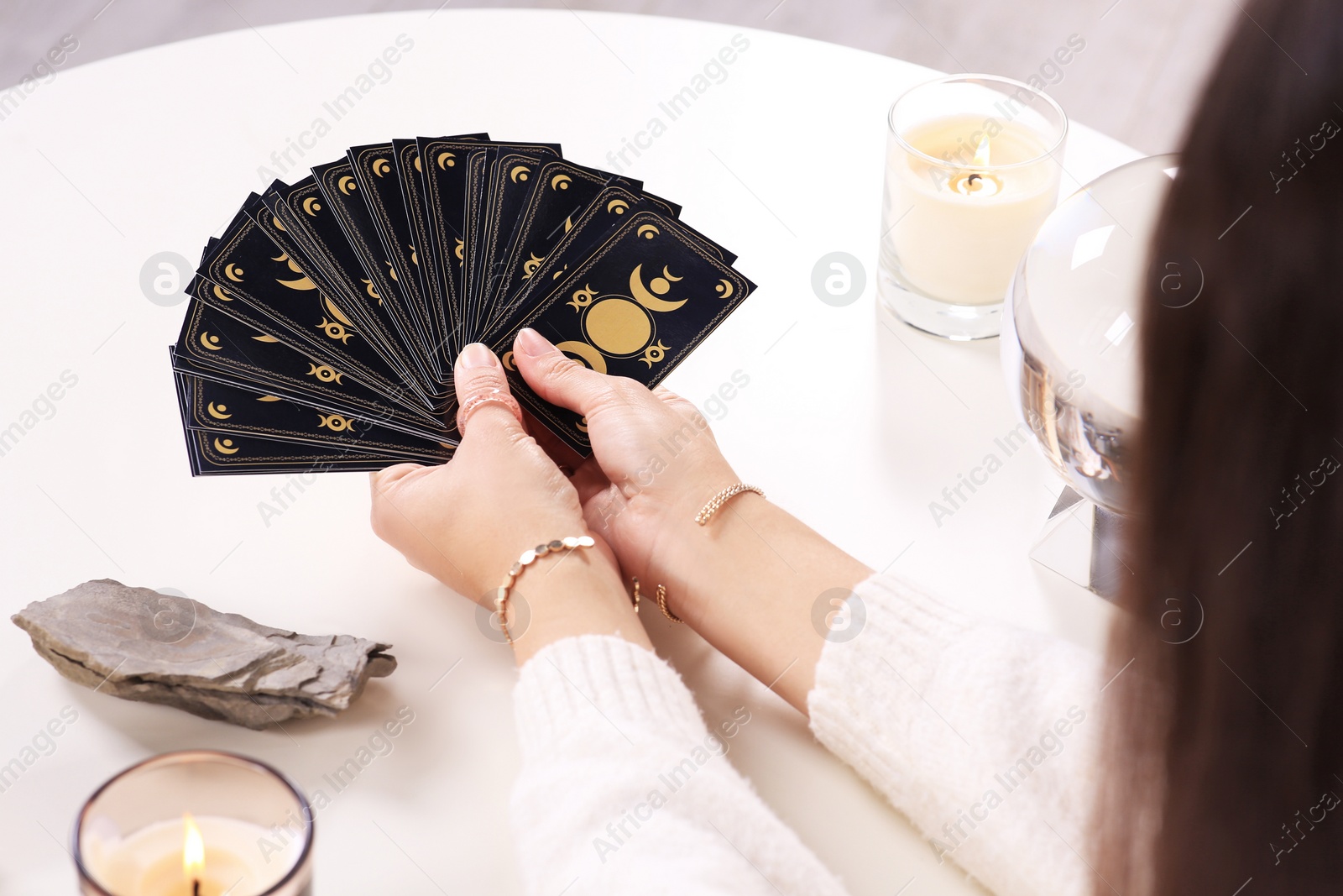 Photo of Soothsayer with tarot card at table, closeup