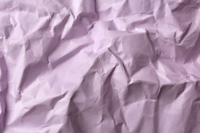 Sheet of crumpled lilac paper as background, top view