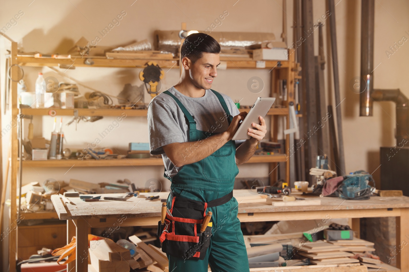 Photo of Professional carpenter with tablet in modern workshop