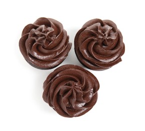 Delicious chocolate cupcakes with cream on white background, top view