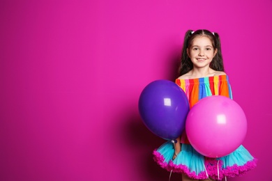 Photo of Cute girl with balloons on color background. Birthday celebration