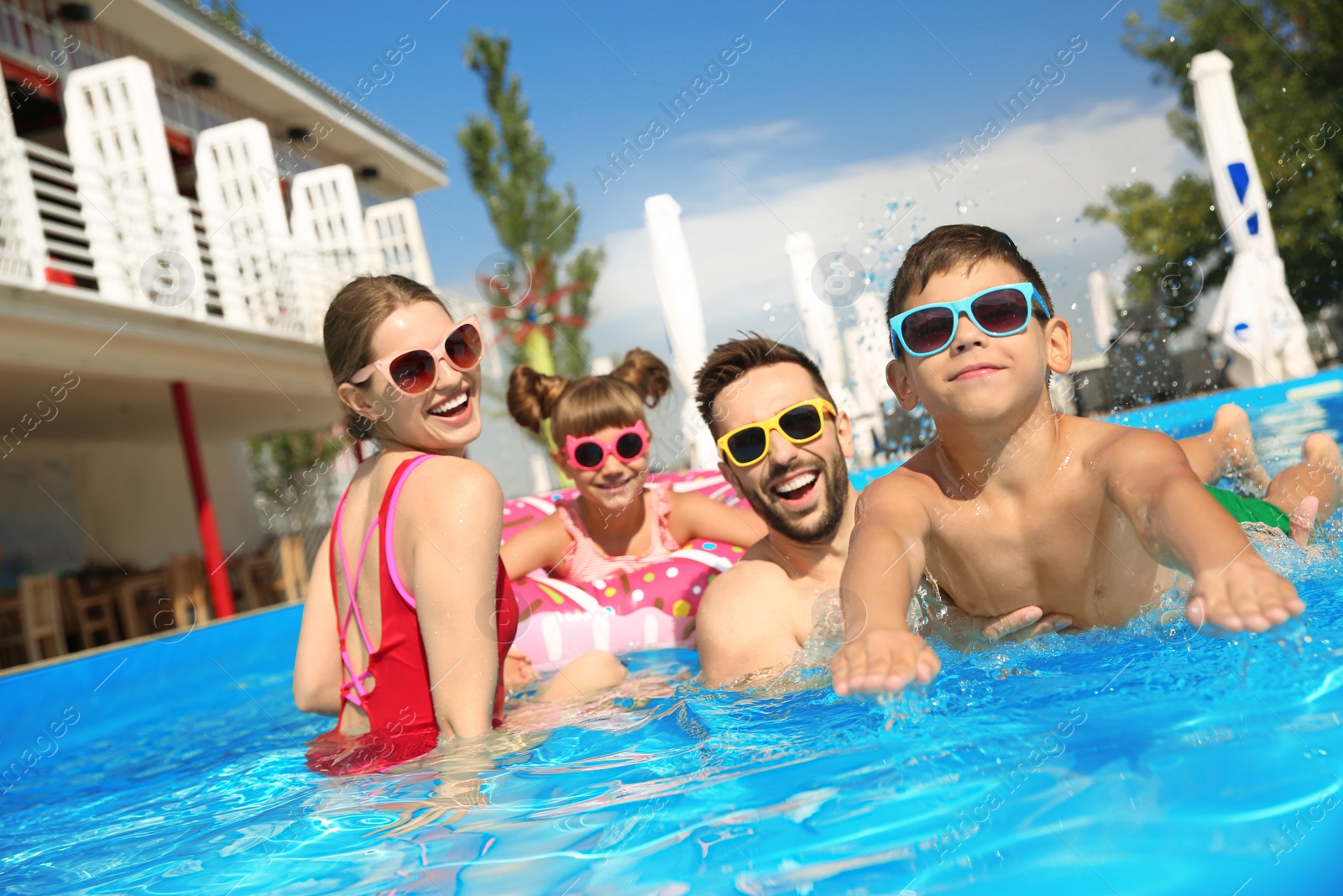 Photo of Happy family in swimming pool on sunny day